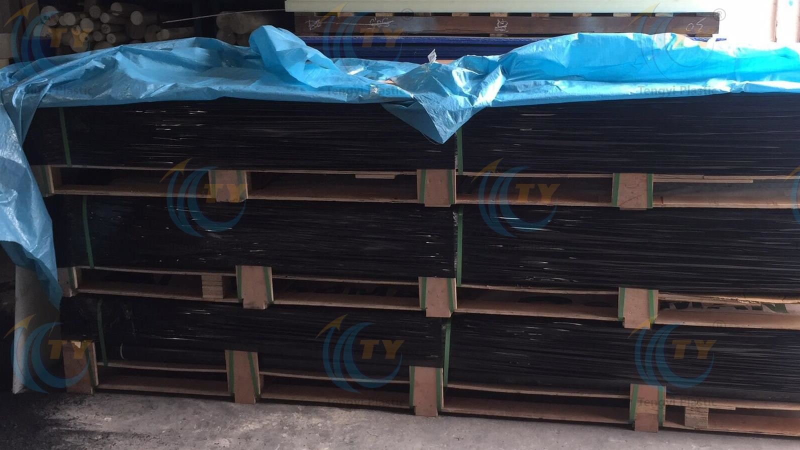 Black POM rods on wooden pallet wrapped with protective PE film